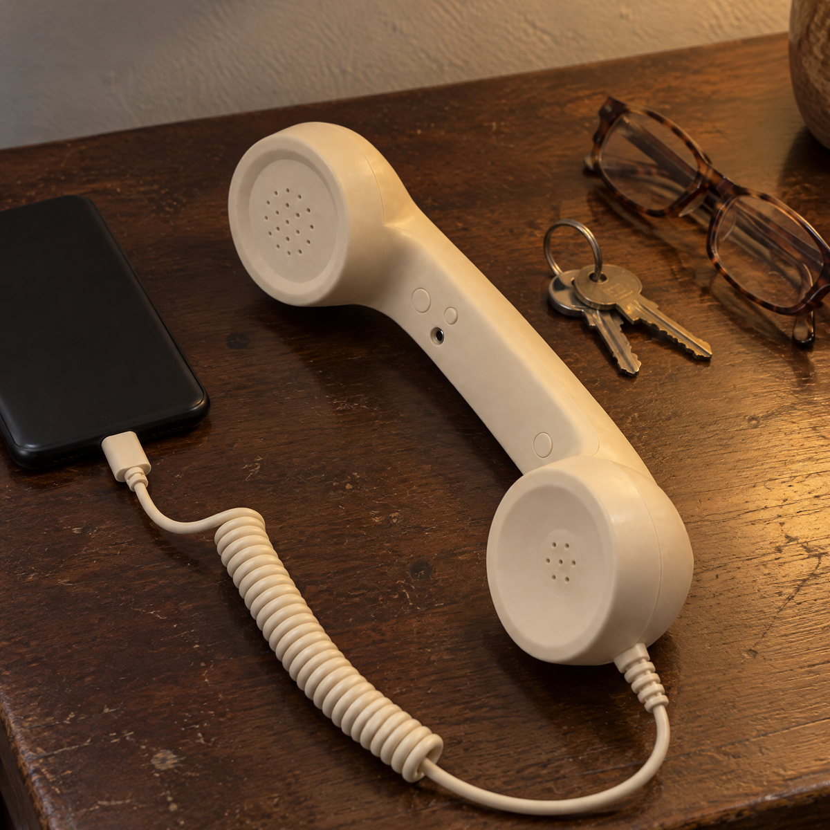 The handset on a hall table beside keys and glasses